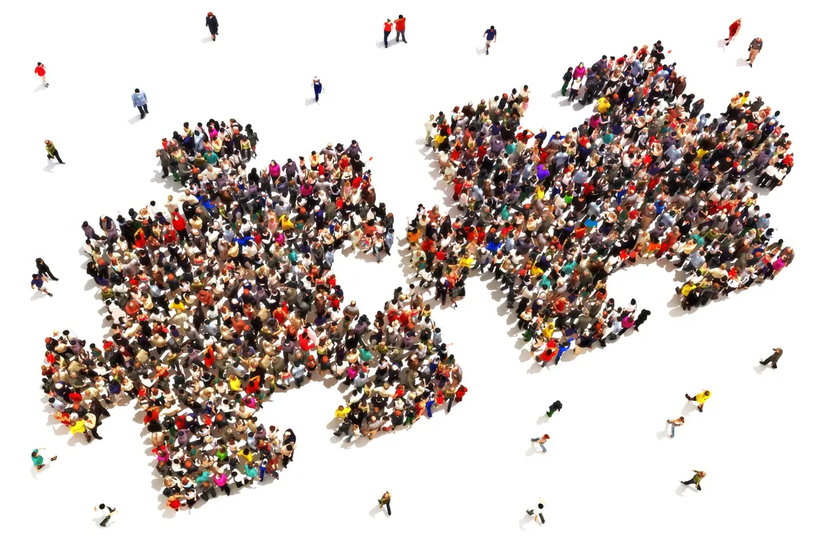Two groups of people forming interlocking puzzle pieces