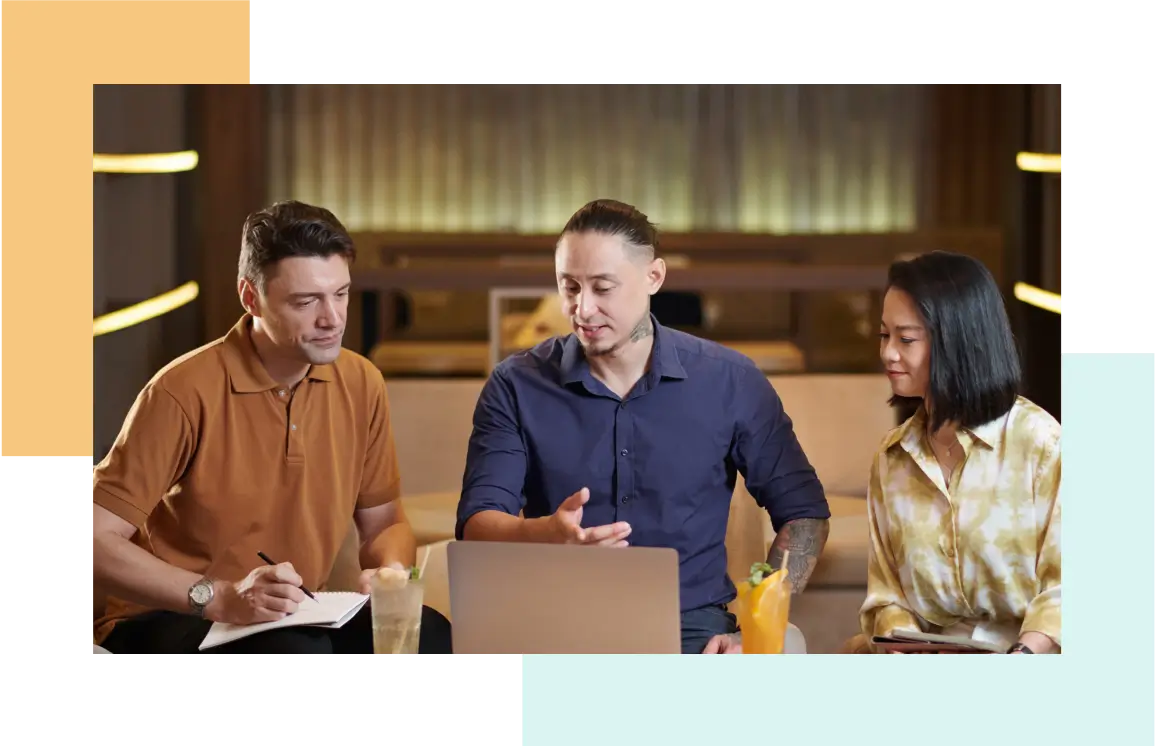 Three people collaborating around a laptop