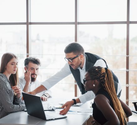 A cross-sector team working together around a laptop